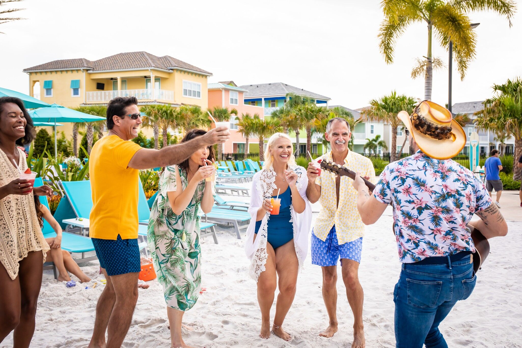 Group of couples with specialty cocktails dancing in the sand to a live musician at Margaritaville Resort Orlando